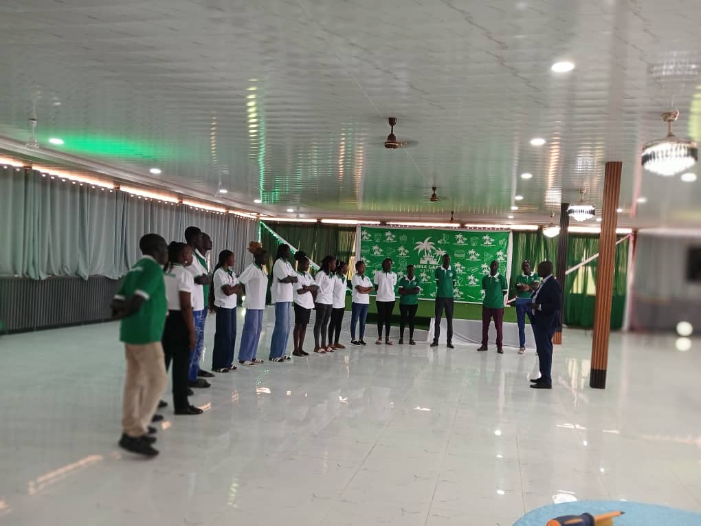 Staff in green and white uniforms lined up under the branded backdrop at the Castle Garden Center launch